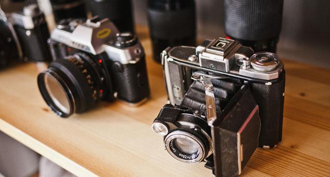 Cámaras fotográficas sobre una repisa de madera